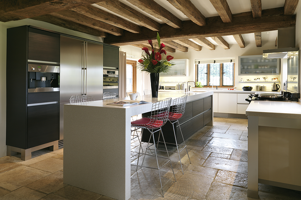 white kitchen with stone tiles and red metal chairs