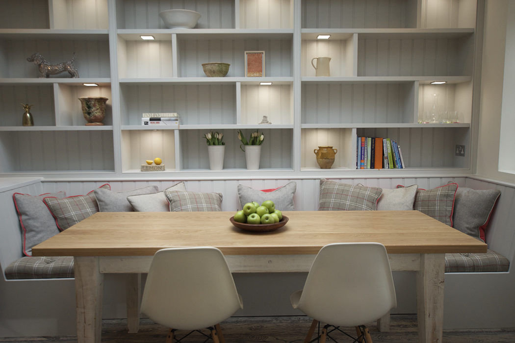 white kitchen with stone tiles and red metal chairs